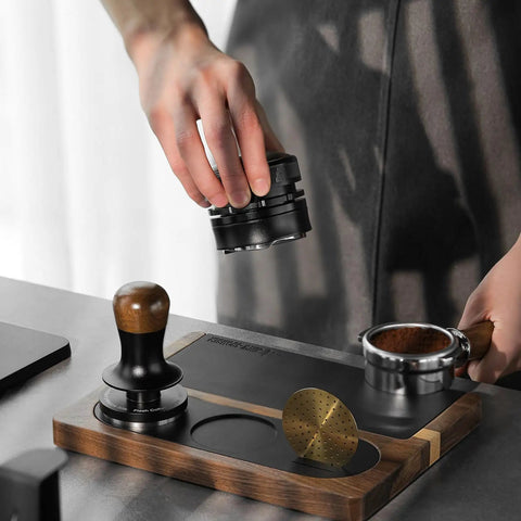 Person using All In One Dope Espresso Tamping Station With Distributor And Tamper Holder Including Tamping Mat And Milk Pitcher Mat Fits 51mm 53mm 54mm 58mm Portafilters Wooden Gold Finish Coffee Accessories Easy Access Stand.