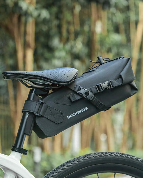 Expandable Waterproof Bikepacking Saddle Bag With 3L Capacity Large Seat Bag mounted on bike, durable construction, forest background.