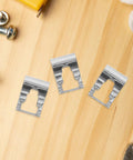 Universal Auto Windshield Wiper Linkage Repair Clips Kit Built Tough With Heavy Duty Stainless Steel showing three clips on wood.