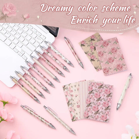 Floral Rose Pink Pen And Notepad Gift Set With 12 Flower Ballpoint Pens And 12 Pretty Notepads on a pink desk by a keyboard.