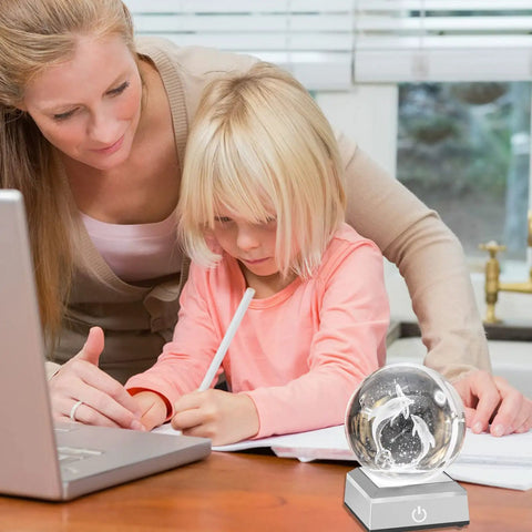 Mom and child using a laptop with a 3D crystal display on a rounded LED base designed for 3D laser crystal engravings.