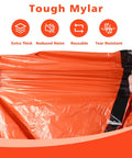 Hands stretching an orange waterproof Emergency Mylar Sleeping Bag Set for Camping showing durability and thickness.