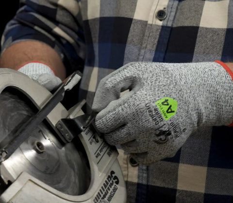 Person using Liquid Repellent Nitrile Work Gloves With Foam Palm Coating, ANSI A4 Cut Protection while operating a saw.