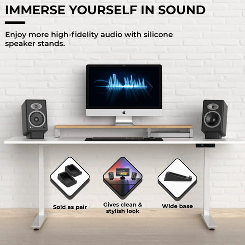 Angled Desktop Speaker Stands With Anti Slip Silicone Wedges for Medium Speakers displayed on a white desk with computer monitor.