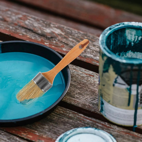 Wood handle paint stain brush with oval synthetic bristles resting on blue paint tray, part of 2 Piece Wood Handle Paint Stain Brushes With Oval Synthetic Bristles For Wood Stain And Wall Paint Deck Brush For Furniture And Wall Treatments This Pro Painting Tools Set Delivers Smooth Finishes And Easy Cleanup