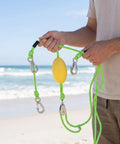 Person holding Marine Tow Line With Pulley And Stainless Steel Bungee Dock Line For Heavy Water Sports Auto Adjust Tension Shock Absorbing Center Pulley Reliable Tow And Docking Gear Green And Black.