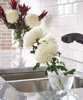 Brecklyn Mediterranean Bronze Single Handle Pull Out Sprayer Kitchen Faucet With Power Clean Tech in use on flowers