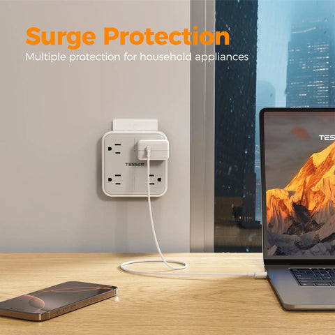 Frictionless Multi Plug Outlet Extender With Four AC Power Jacks And Three Fast USB Charging Ports Smooth Design Wall Tap For Desk Home Office Setup mounted on wall with charger and laptop.