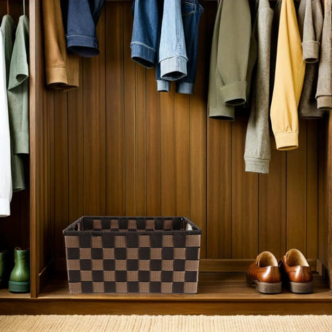 Top Shelf Clothing Storage Bin With Reinforced Metal Frame And Grippy Polyester Weave Handles, placed in a closet, with hanging clothes.