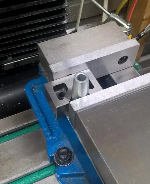 Rock Solid Cast Iron V Block Set For Precision Layout Work And Machinist Bench Setup Featuring Dead Square Ground Edges And Point Zero Zero Zero One Inch Tolerance That Is Seriously Badass Quality positioned on CNC machine with cylindrical part.