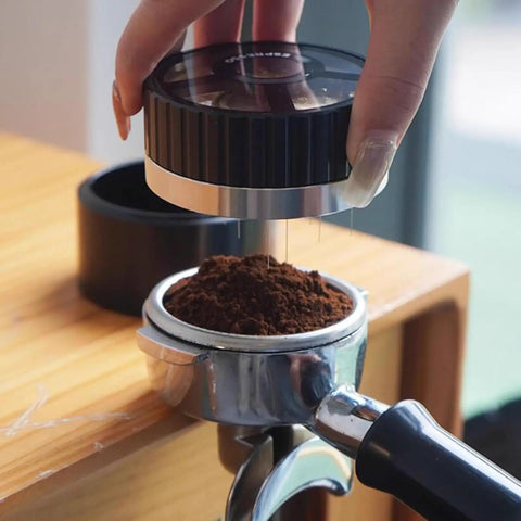 Slick 58mm Coffee Distributor Needle With Geared Spinning Action And Sturdy Black Base, Smooth Espresso Leveler For Flawless Puck Prep, Legit Home Barista Essential Brewing Gear, user preparing ground coffee.