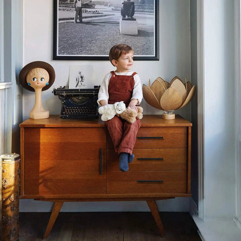 Child sitting on vintage cabinet with 45 Pack Matte Black Stainless Steel Cabinet Pulls 7.38 Inch Length With 5 Inch Hole Center Dope Modern Kitchen Drawer Cupboard Handles For Cabinets Easy Install And Lasting Finish in a cozy room.