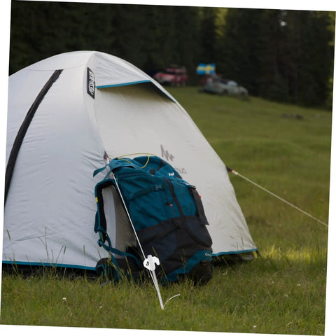 Heavy Duty Tent Stakes Ground Nails Kit anchoring a camping tent and backpack on grass with forest background.