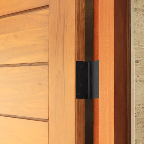 Four Inch Matte Black Interior Door Hinges Value Pack With Three Heavy Duty Leaves Pre Lubricated For Dead Silent Swing, shown on a wooden door.