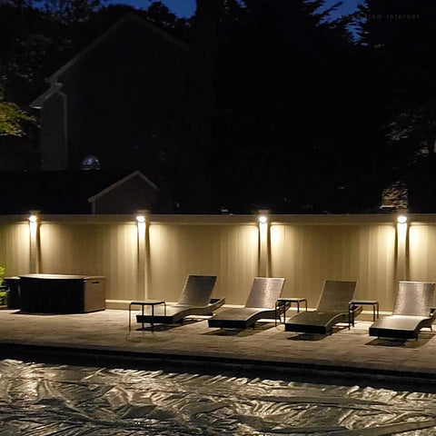 Low Voltage LED Deck Lights Set For Outdoors illuminating a backyard patio with lounge chairs at night, 170 Lumen, brown finish