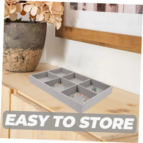 Three Piece Multi Grid Jewelry Organizer Trays featuring earring stands, grey velvet storage tray with bracelets and rings on table.