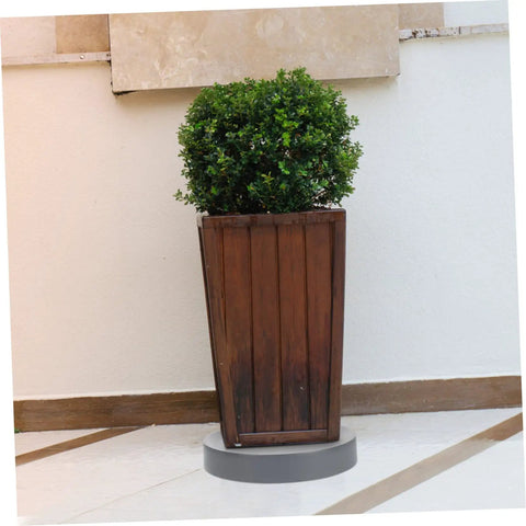 Heavy Duty Pot Trolley With Four Smooth Swivel Wheels Crafted as a No Sweat Garden Mover and Hella Tough Planter Cart for Large Flower Pots Indoors or Outdoors holding a wooden planter with a bush.
