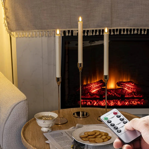 Flameless Taper Candles With Remote And Timer Battery Operated Led Flickering Ivory Plastic Candlesticks For Christmas Decor Three Pack With Realistic Drip Wax Look No Melt No Mess Safe Soft Glow shown lit on a table by fireplace.