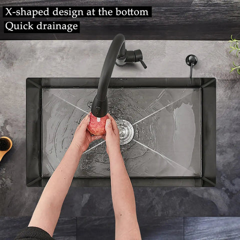 Overhead view of 20 Inch Black Stainless Steel Kitchen Sink Single Bowl Nano Self Cleaning Undercounter Workstation With Accessories Pro Grade Quiet Built In Design Stain Resistant And Easy To Clean, showing quick drainage feature with hands washing an apple.