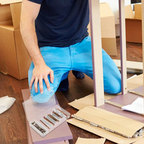 Person assembling furniture with a 49 Piece M6 X 40 To 80Mm Hex Socket Screws And Barrel Nuts Hardware Kit in view.