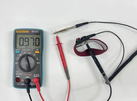 Anti Static Wrist Strap Band With Grounding Wire For ESD and multimeter on white surface.