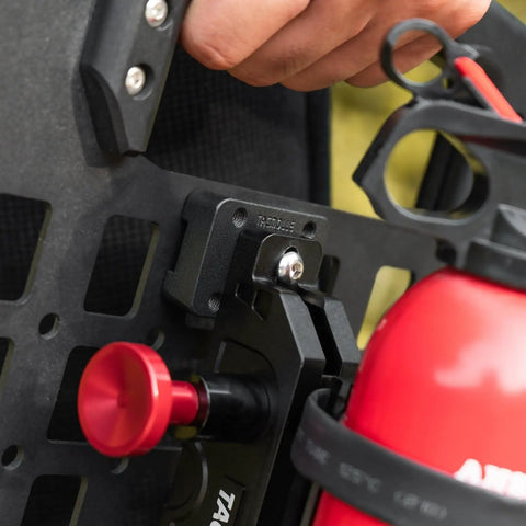 Close-up of Mounting Bracket Base For MOLLE Panels 2 Pack Ready To Roll Universal Adapter installed with fire extinguisher.
