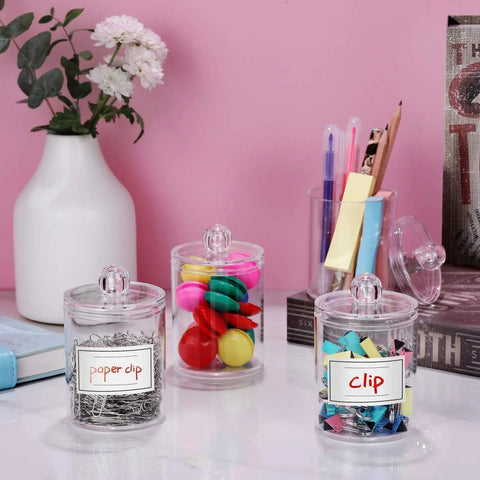 Super Practical Four Pack Clear Acrylic Qtip Holder Dispensers With Lids For Organizing Cotton Swabs Balls Pads And Floss Picks Comes With Labels In Two Sizes Twelve Ounce And Ten Ounce with colorful contents.