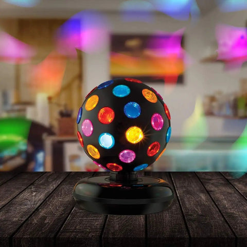 Spinning 11 Inch Disco Ball With LED Lights And 360 Degree Rotation for parties on a wooden table illuminating room with colorful lights