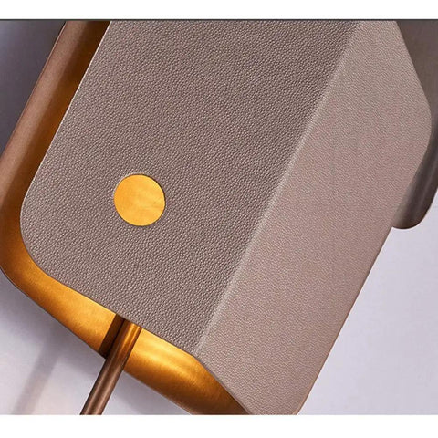 Close-up of the Top Shelf Modern LED Wall Sconce showcasing leather and gold accents, ideal for relaxed living rooms.