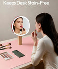 Leather Desk Protector Mat For Office And Home Large Mouse Pad Non Slip PU Leather Blotter Waterproof Writing Pad Light Pink 23.6 By 13.8 Inches Perfect For Your Laptop Keyboard And Desk Setup. Woman applies makeup on mat.