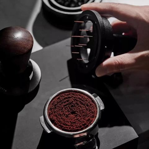 Image of 58mm Espresso Needle Distributor Features Nine Fine Thin Needles Adjustable Height Frame above ground coffee in portafilter.