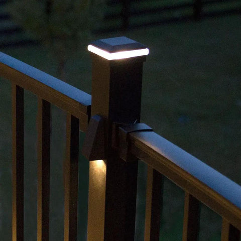 LED Aluminum Post Cap Light For 2.5 Inch Railing Posts With 360 Degree Illumination in Charcoal Black on deck at night.