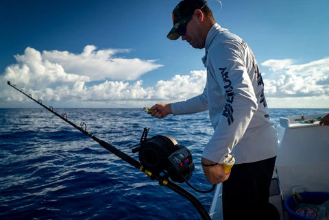 Man using Rock Solid Adjustable Deep Drop Lead Holder For Gunnel Rods Heavy Duty Anodized Aluminum Fishing Rig on boat.