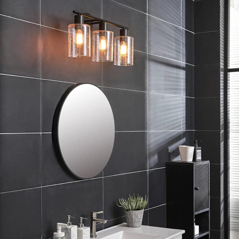 Bristol 5 Piece All In One Matte Black Bathroom Set With Dimmable 3 Light Vanity Light Featuring Seeded Glass Shades on black tile wall.