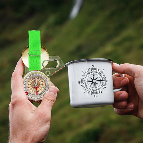 Trail Ready Thumb Orienteering Hiking Compass With Quick Reset Needle Pocket Size For Outdoor Navigation And Backpacking Adventures Waterproof Durable Acrylic Shell Great For Hiking Camping Trails And Backcountry Travel held beside a compass-themed mug