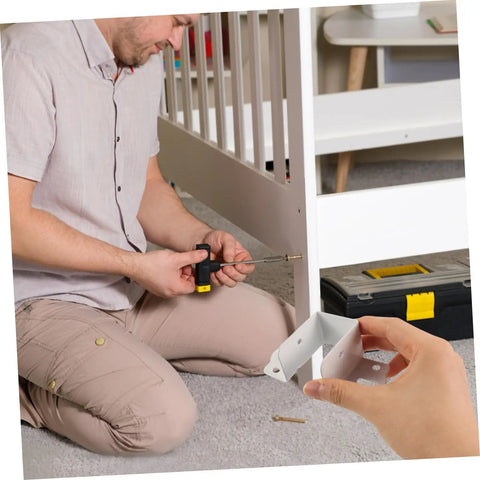 Man assembling furniture using Built Tough Metal Bed Rail Fasteners Twenty Piece Hinge Buckles And Snappy Slide Hooks For No Sweat Bed Frame Setup.