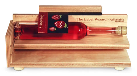 Adjustable Label Applicator Tool For Round Bottles Jars And Candles Slick Peel And Stick Positioner on wooden base with bottle.