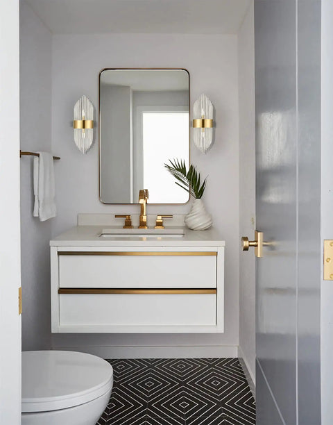 Mid Century Brass Wall Sconce With Glass Rods installed beside a bathroom vanity mirror