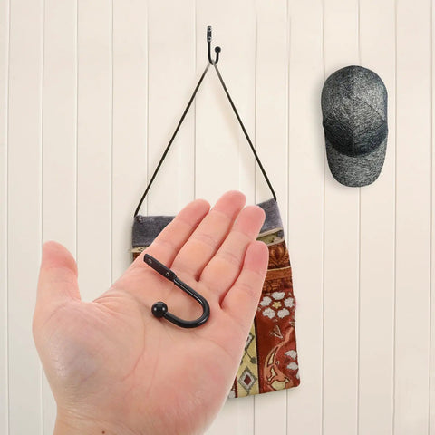 Grab These Bad Boys 12 Pack Black Mini Metal Wall Mount Coat Hooks For Doors And Walls Vintage Style held in hand with wall mounted cap.