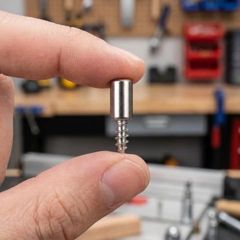 Close-up of a hand holding a Heavy Duty Cabinet Shelf Peg Set with 0.3 inch pin, part of 150 Self Tapping Screws And 150 Sleeves kit.