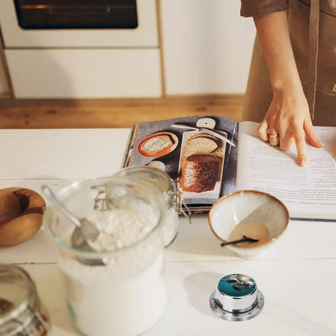 Go To Ocean Penguin Stainless Steel Timer With Magnetic Base on kitchen counter near baking ingredients and cookbook