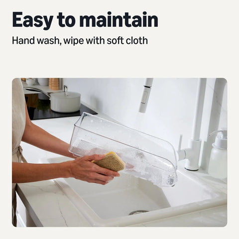 Person cleaning the Clear Two Pack Can Organizer For Fridge Pantry with a sponge at a sink, demonstrating easy maintenance.