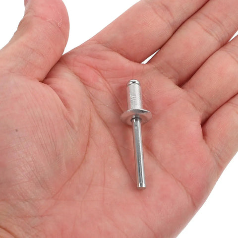Hand holding single aluminum rivet from 140 Piece Aluminum Blind Rivet Kit With Flange Long Grip Pop Rivets For Auto And Furniture Repairs.