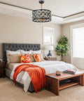 Bedroom with elegant vintage crystal chandelier in matte black with gold accents above bed, matching product description.