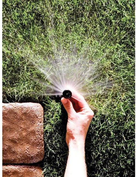 Person adjusting High Efficiency Adjustable Sprinkler Nozzles 0 To 360 Degree Pattern With 5 To 8 Feet Spray Distance 5 Pack on lawn.