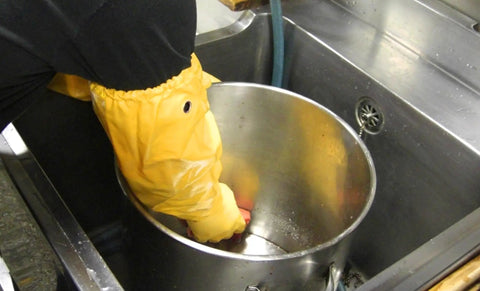 Person using Double Nitrile Coated Full Arm Chemical Resistant Safety Glove With Cotton Poly Liner, 20 Mil Thick for cleaning metal pot