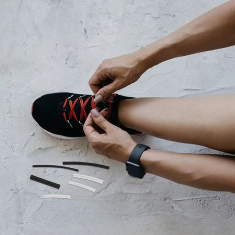 DIY Shoe Lace Repair Kit With 78 Reusable Plastic End Caps And Heat Shrink Tips To Fix Snaggy Sneakers And Formal Laces Anytime Without Buying New Ones For A Fresh Look. Black sneaker with hands replacing red laces and spare tips.