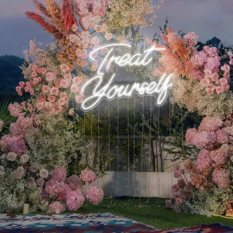 Treat Yourself Neon LED Light For Walls amidst colorful floral backdrop outdoors