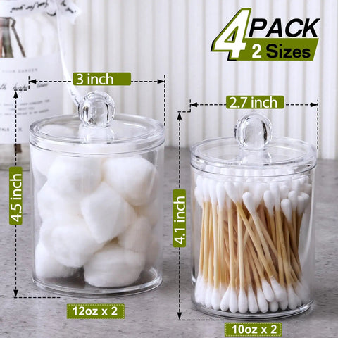 Super Practical Four Pack Clear Acrylic Qtip Holder Dispensers With Lids For Organizing Cotton Swabs Balls Pads And Floss Picks Comes With Labels In Two Sizes Twelve Ounce And Ten Ounce, showing 12oz and 10oz jars on countertop.