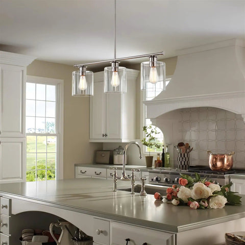 Three Light Kitchen Island Fixture With Clear Glass Cylinder Shades In Warm Brass Finish in modern kitchen setting